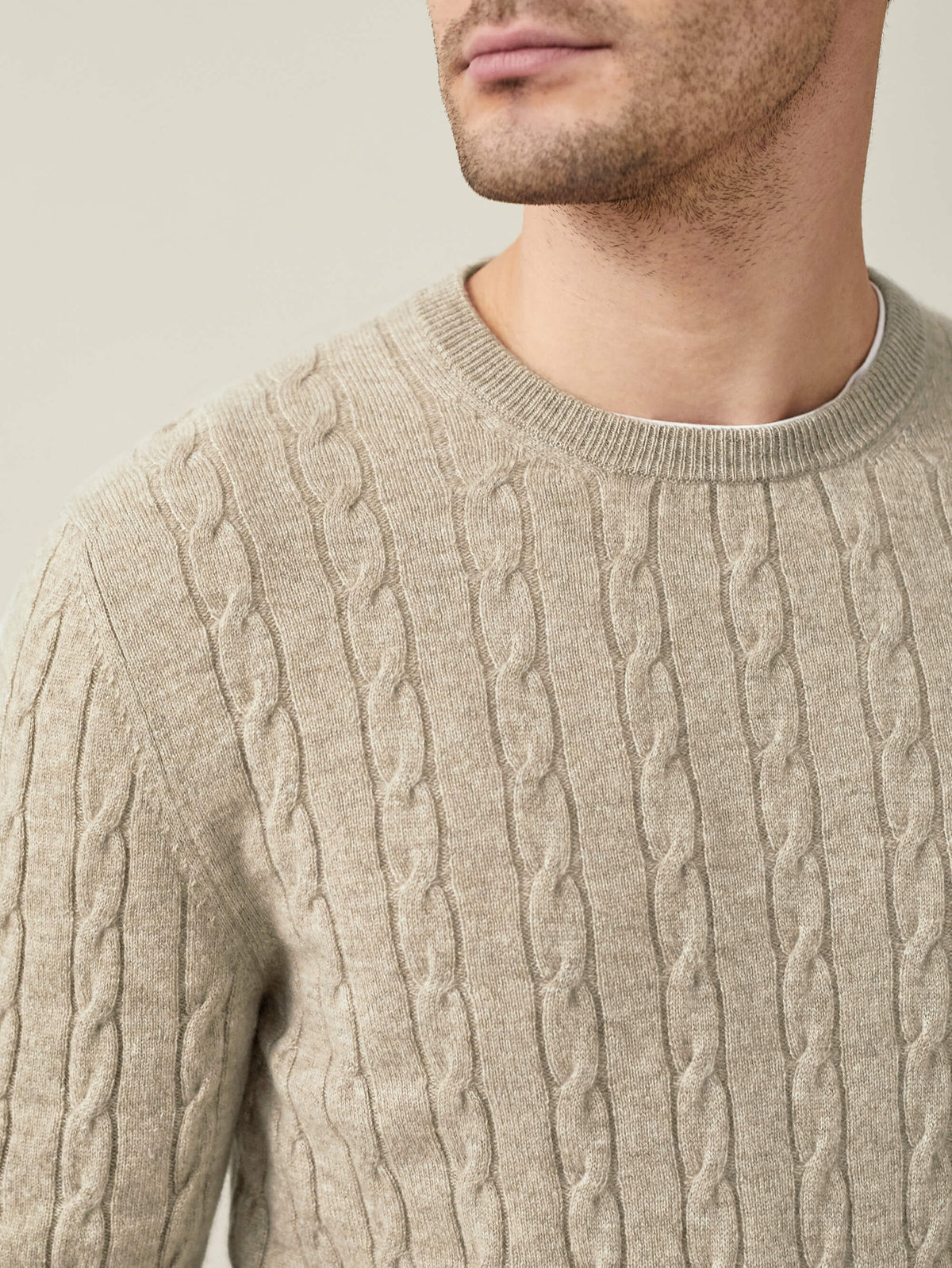 A close-up of the Luca Faloni Cashmere Cable Knit in camel beige, showing the detailed knit texture and crew neckline.