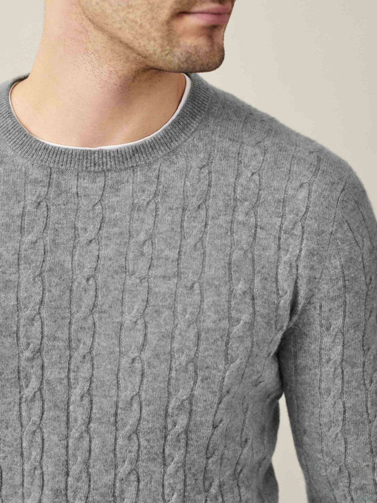 Close-up of the Dolomiti Grey Cashmere Cable Knit, showcasing the intricate texture and classic crew neckline on a model.