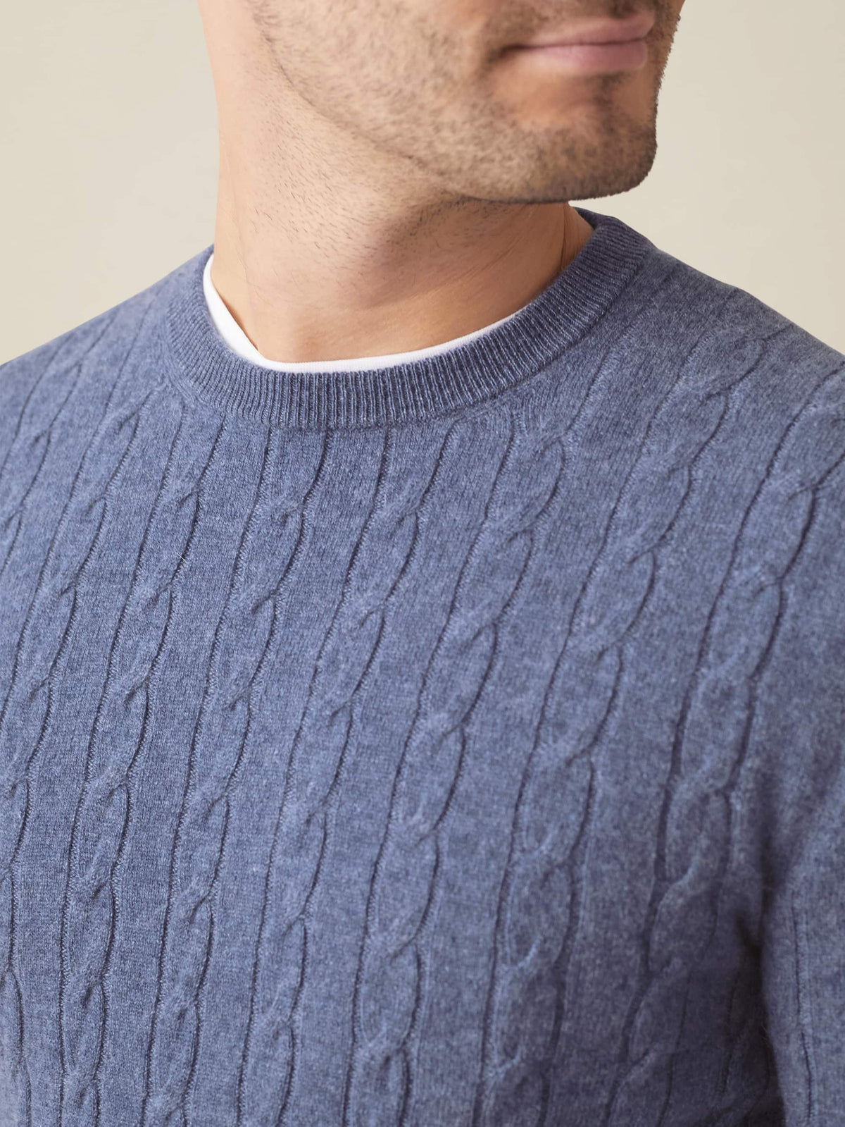 Close-up of a man wearing the Sialia Blue Cashmere Cable Knit jumper, showing the detailed texture and crew neckline.