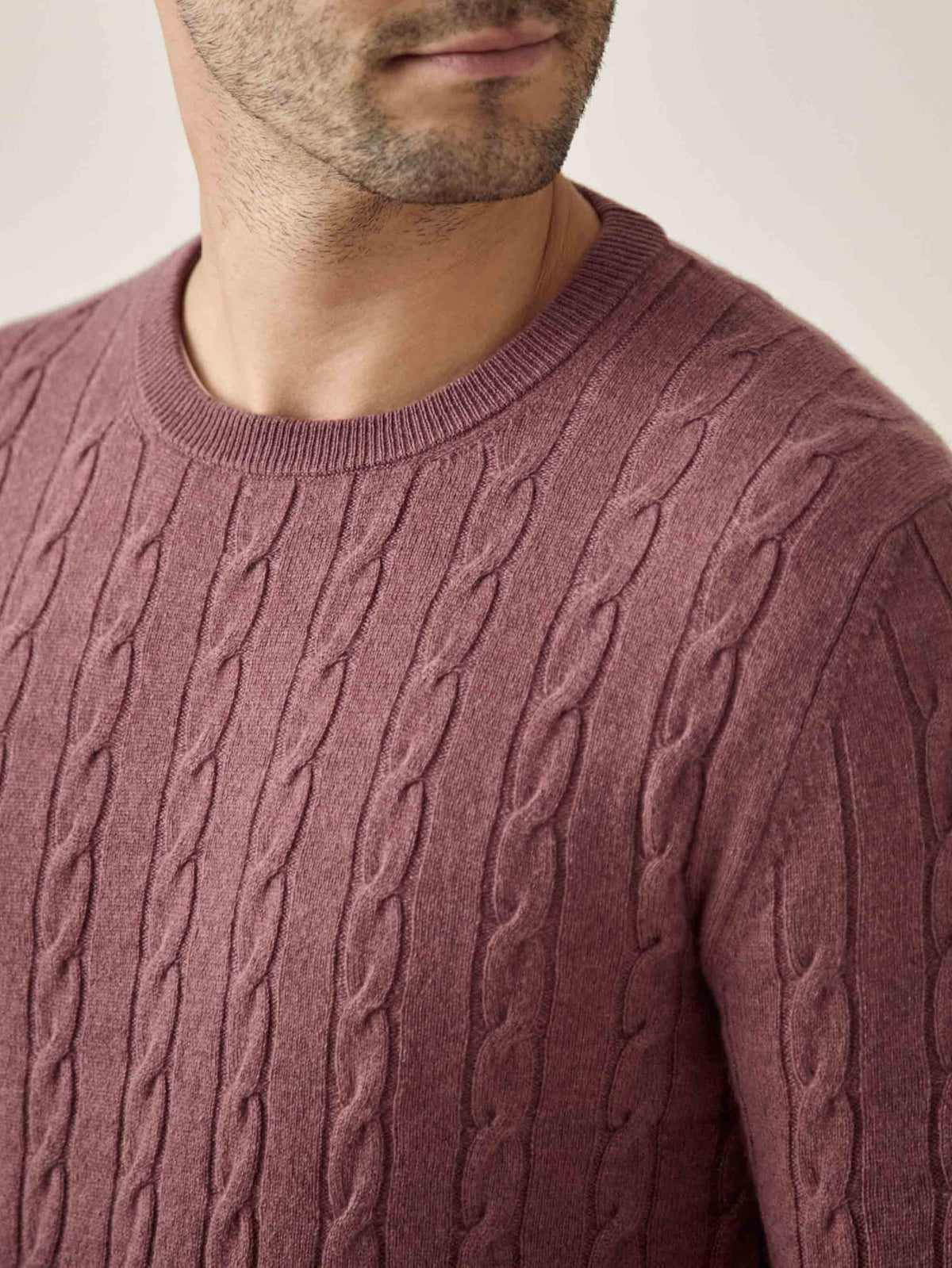 Close-up of a man wearing the Cable Knit jumper in Desert Rose, showing the detailed cashmere knit and crew neckline.
