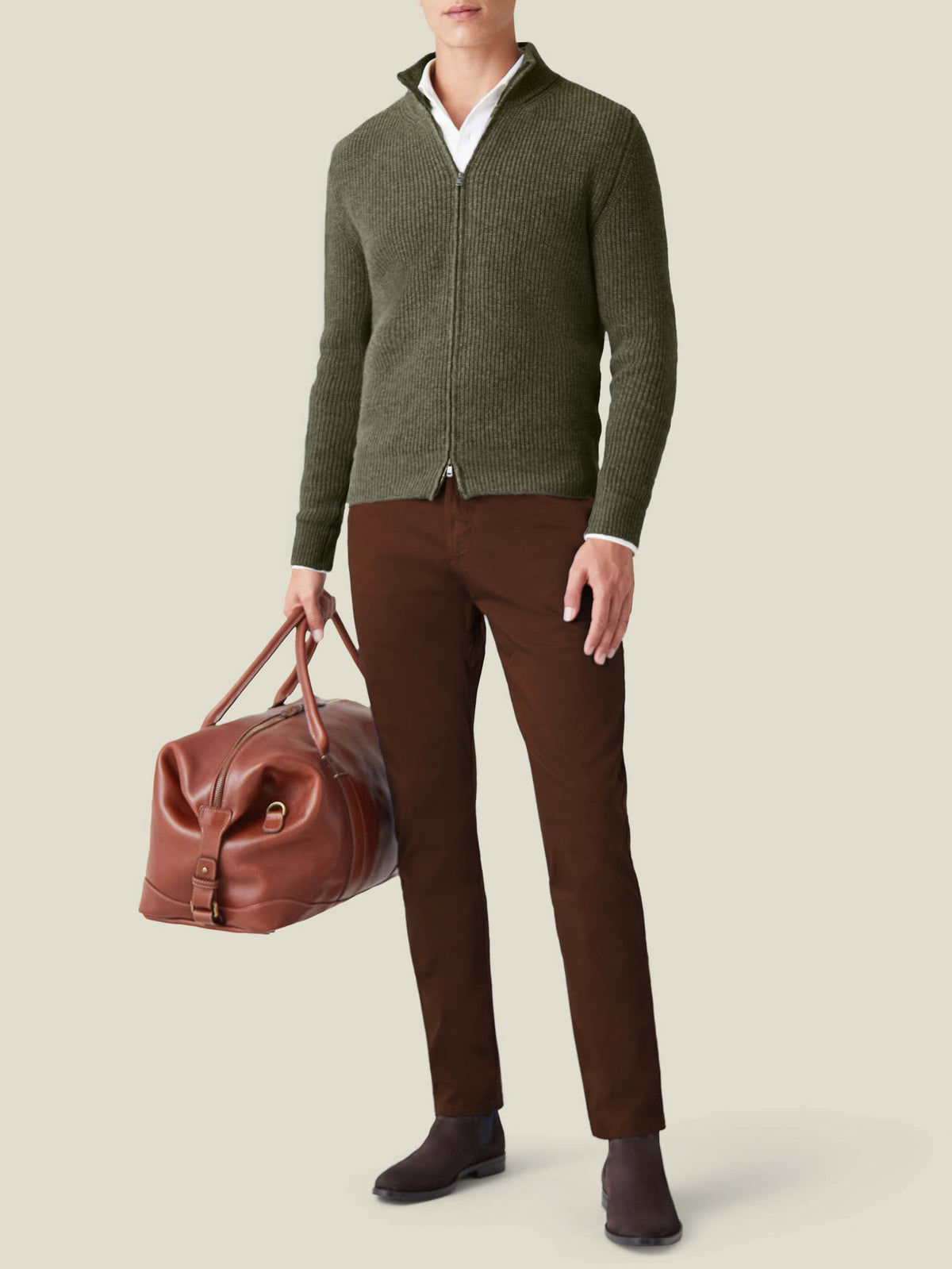 A model wears the Luca Faloni Hunting Green Chunky Knit Zip Cardigan with brown trousers, carrying a brown leather bag.