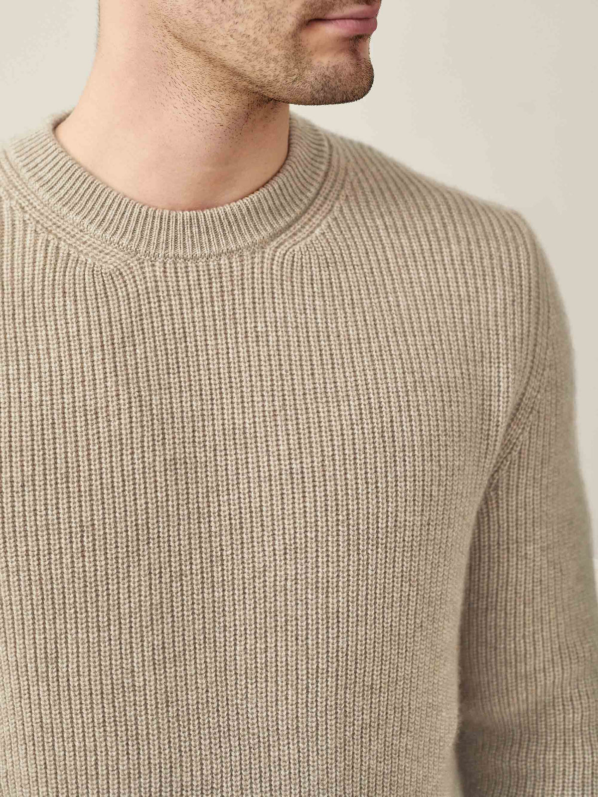 A man wears the Chunky Knit Crew Neck in Camel Beige, with a close-up showing the ribbed four-ply cashmere texture.