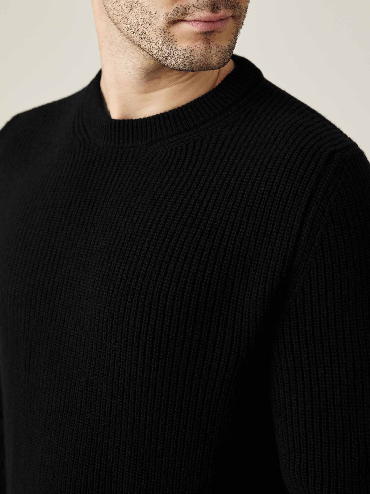A close-up of a man wearing the Black Chunky Knit Cashmere Crew Neck, highlighting the ribbed texture and neckline.