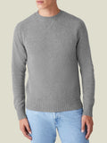 Front view of a model wearing the Dolomiti Grey Cashmere Country Crew Neck, showcasing its heritage cross-stitch collar.