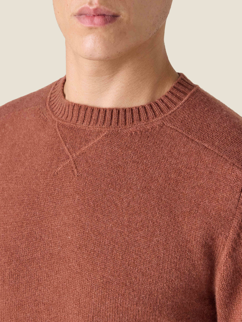 Close-up of the heritage cross-stitch collar on the Luca Faloni Country Crew Neck in rust cashmere, worn by a model.