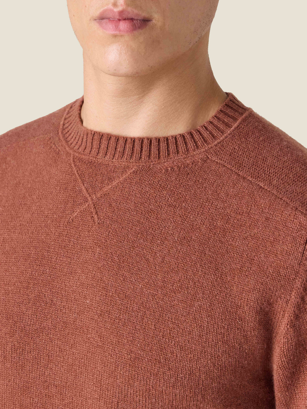 Close-up of the heritage cross-stitch collar on the Luca Faloni Country Crew Neck in rust cashmere, worn by a model.