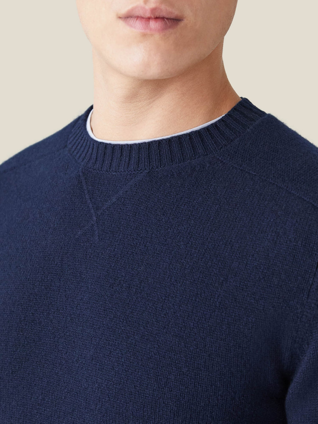 A close-up of the Country Crew Neck in midnight blue cashmere, showcasing the heritage cross-stitch collar.
