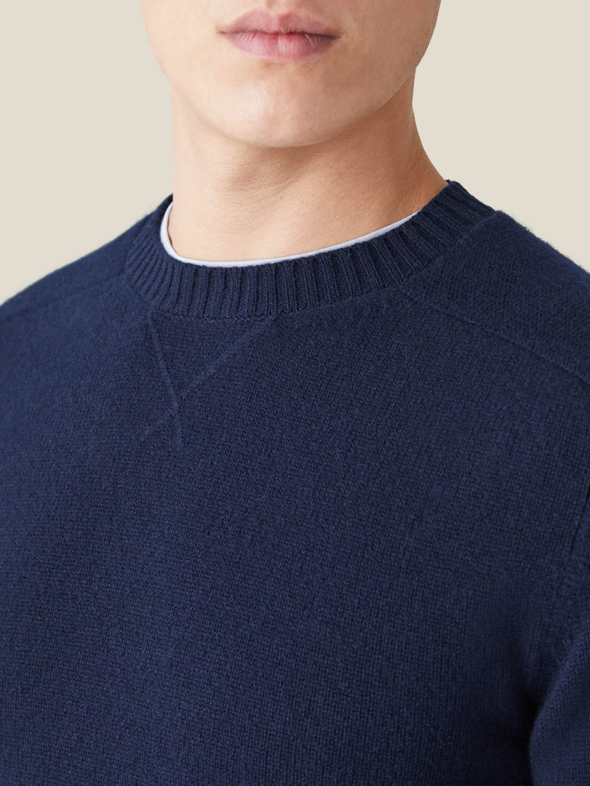 A close-up of the Country Crew Neck in midnight blue cashmere, showcasing the heritage cross-stitch collar.