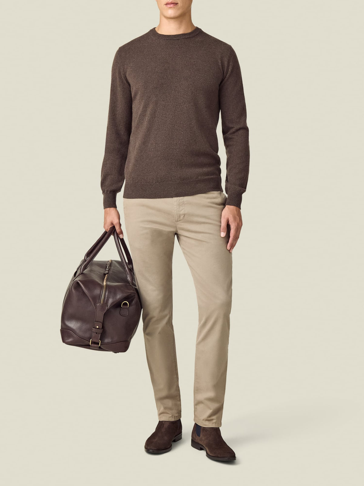 Front view of a model wearing the Luca Faloni Chocolate Brown Cashmere Crew Neck with beige chinos and holding a leather bag.