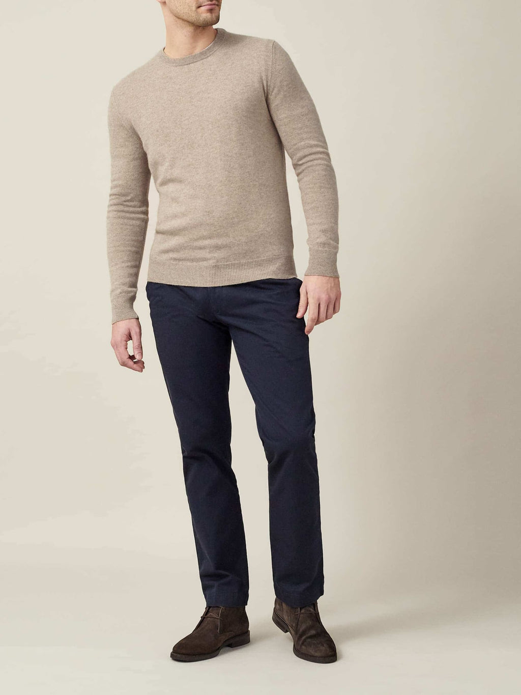 Model wearing the beige cashmere crew neck jumper with navy chinos and dark brown suede boots.