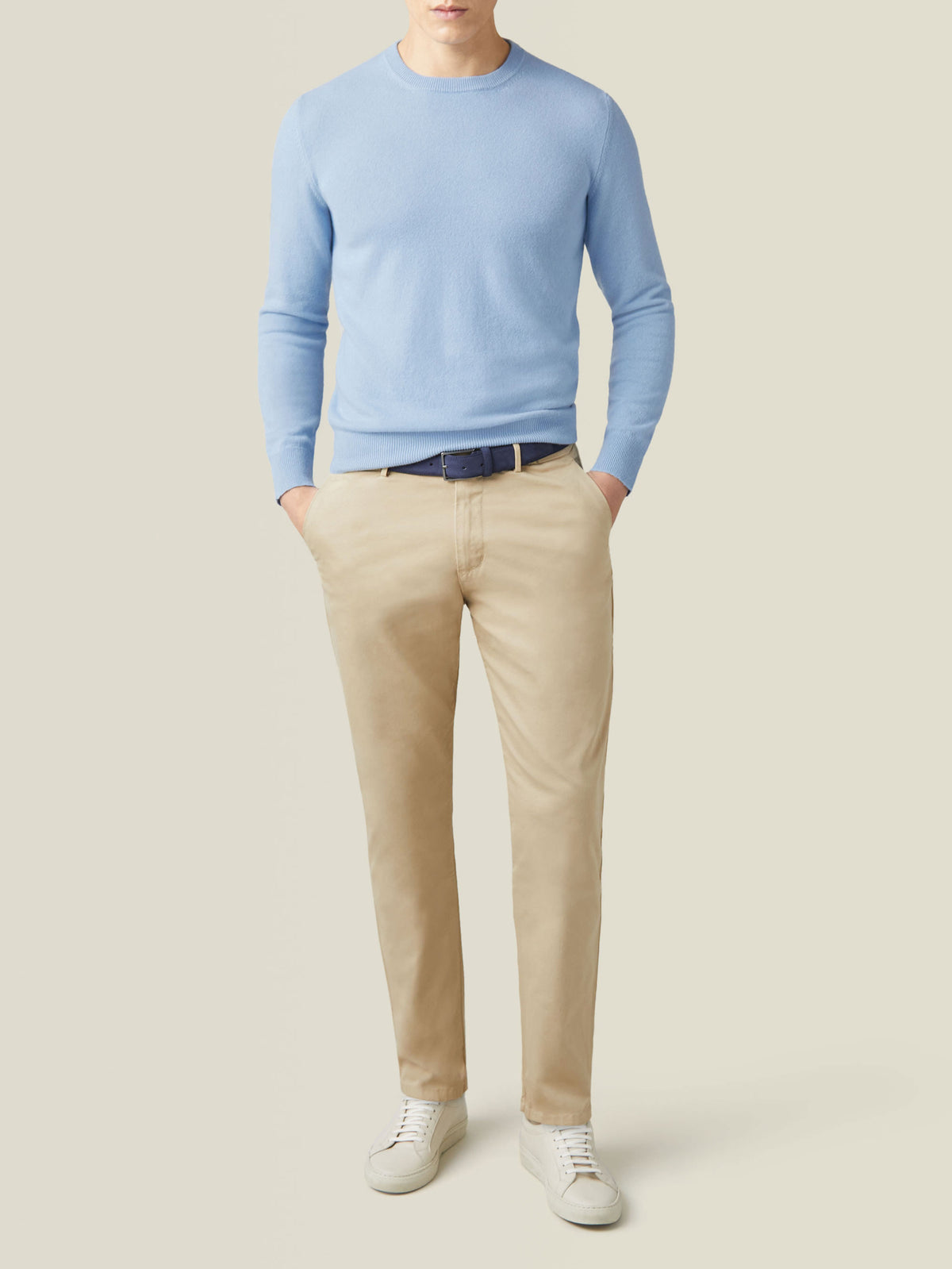 Full outfit view of a model wearing the sky blue cashmere crew neck with light brown chinos and white sneakers.