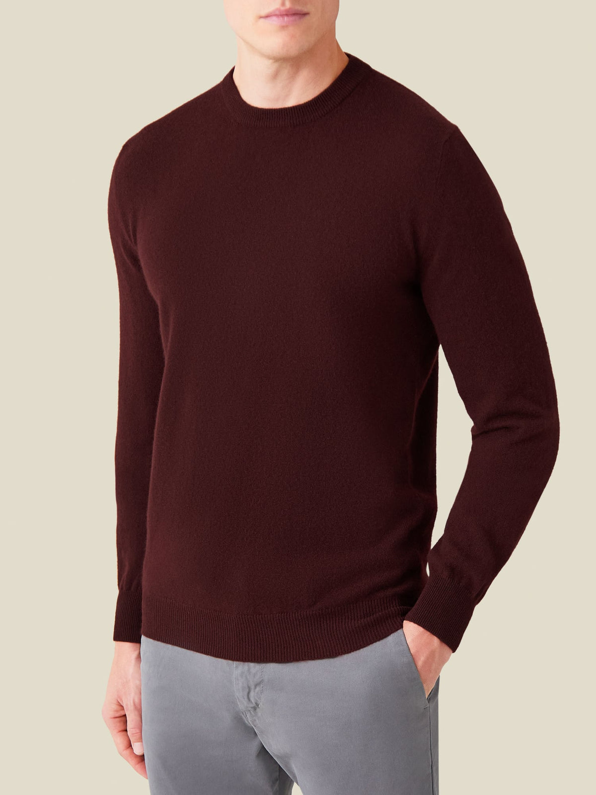 Frontal shot of a model wearing the Luca Faloni Cashmere Crew Neck in Lava Red, paired with grey trousers.