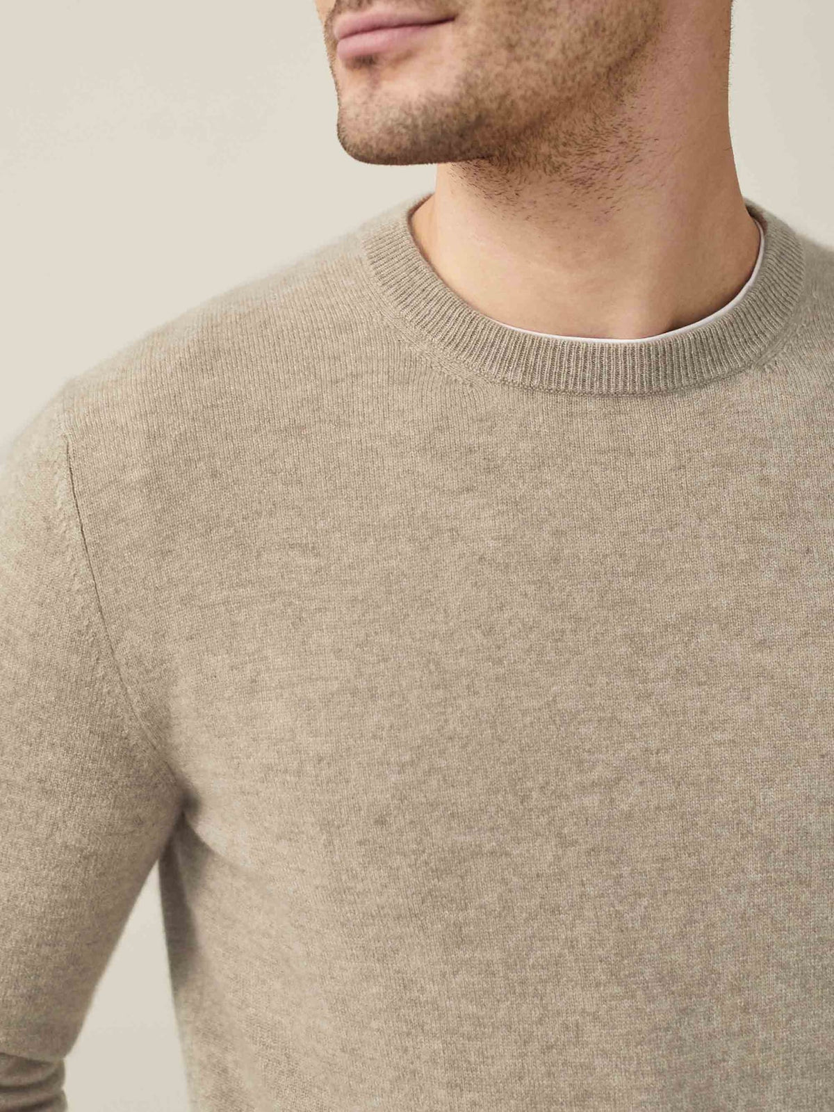 Close-up of the Pure Cashmere Crew Neck in camel beige, showing the ribbed neckline and soft fabric texture.