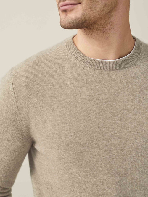 Close-up of the Pure Cashmere Crew Neck in camel beige, showing the ribbed neckline and soft fabric texture.