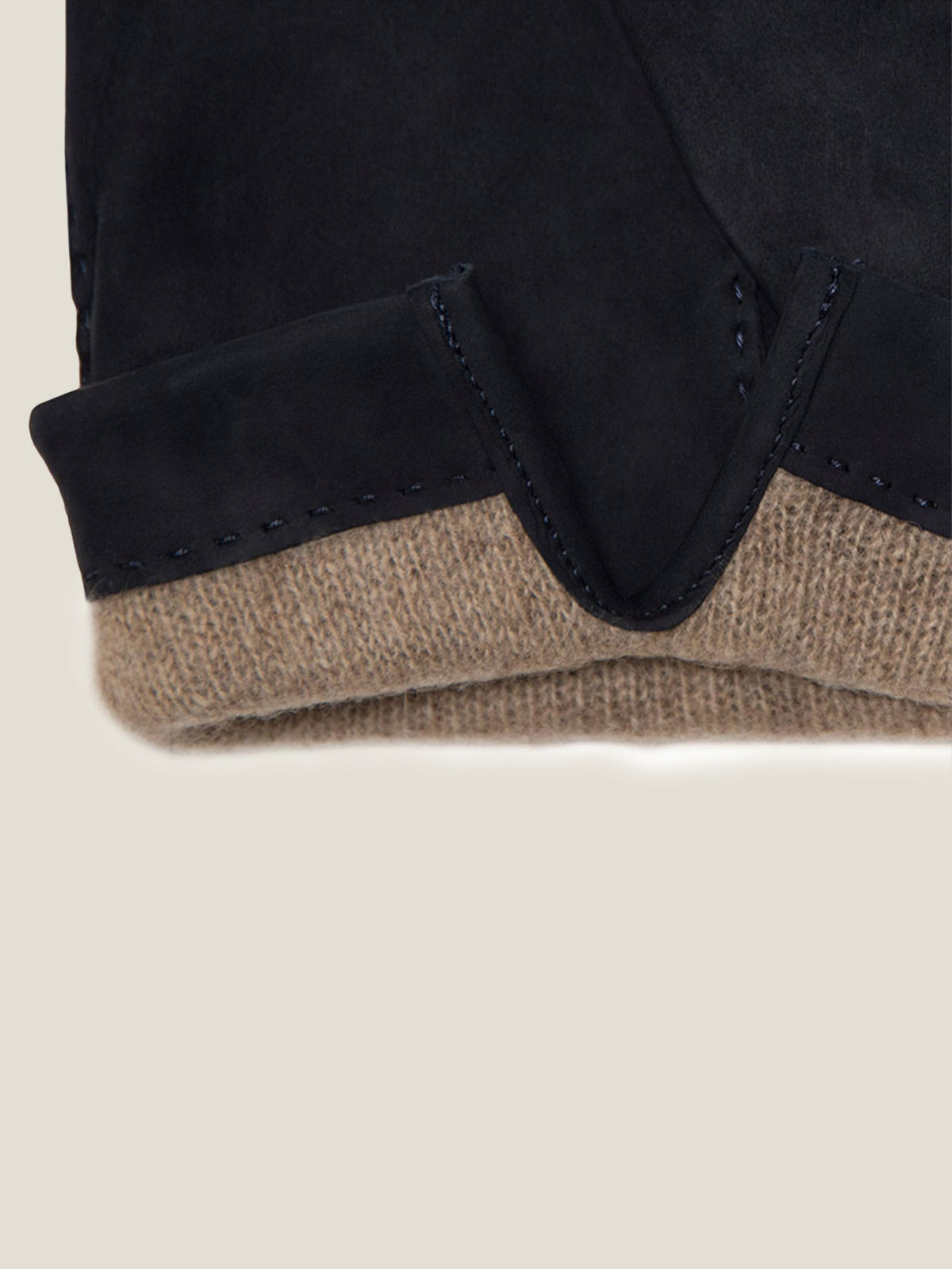 A close-up of Luca Faloni's navy Cashmere-Leather Gloves, showing the nubuck cuff and the soft cashmere lining.