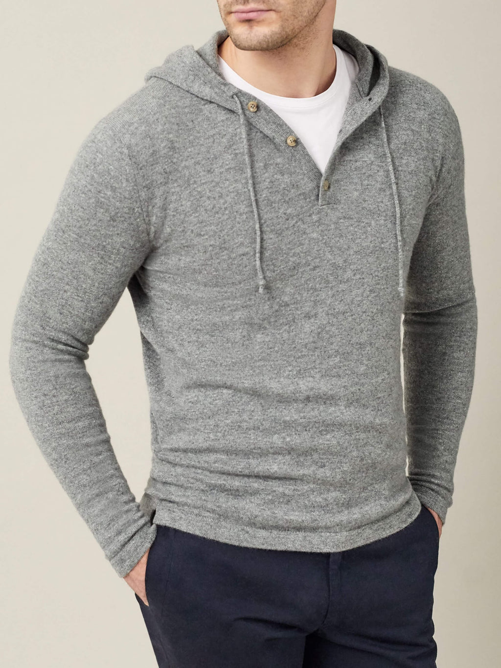 Front view of a model wearing the Luca Faloni pure cashmere hoodie in Dolomiti Grey over a white t-shirt and navy trousers.