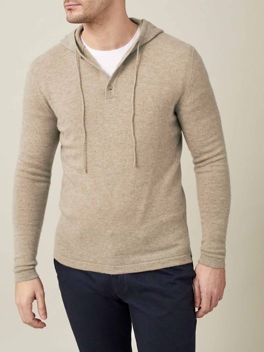 Front view of a model wearing the Luca Faloni two-ply cashmere hoodie in camel beige, styled over a white t-shirt.