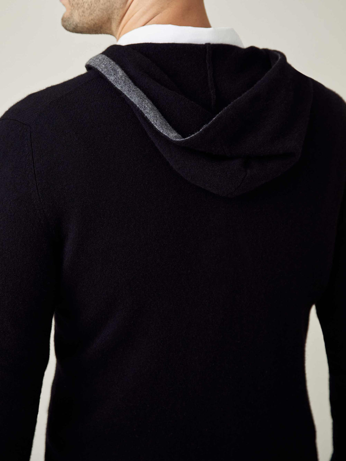 Back view of the Luca Faloni black cashmere hoodie, highlighting the contrasting grey lining of the hood.