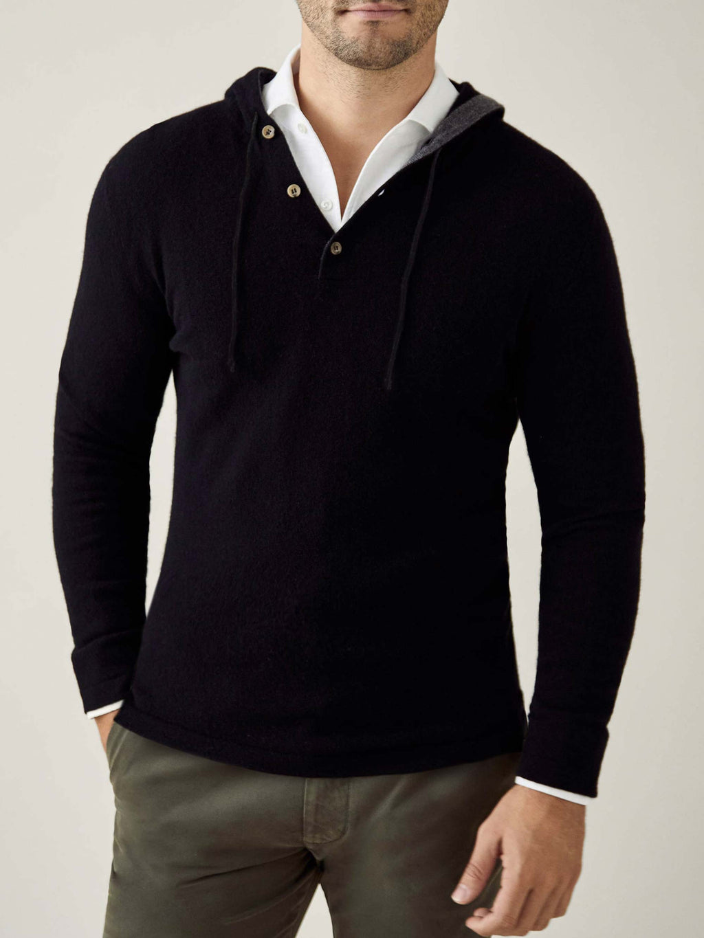 Front view of a model wearing the Luca Faloni black pure cashmere hoodie layered over a white collared shirt.