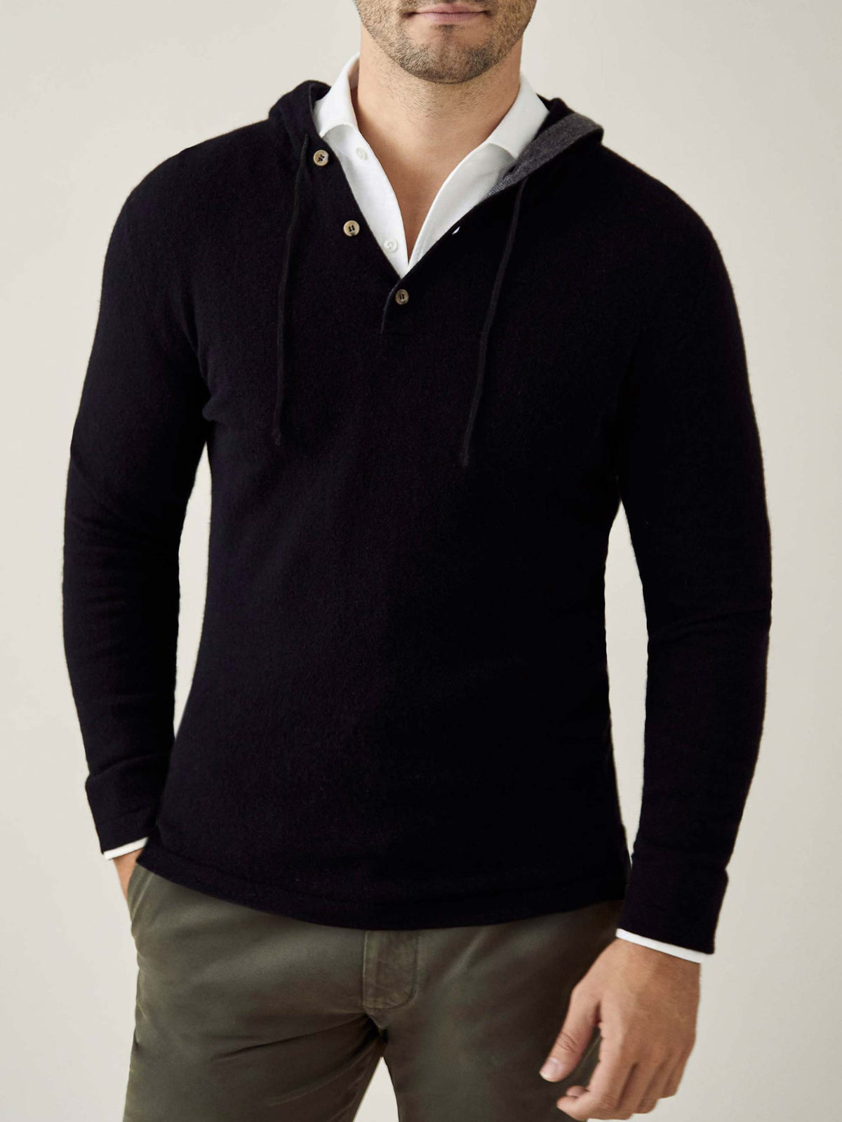 Front view of a model wearing the Luca Faloni black pure cashmere hoodie layered over a white collared shirt.