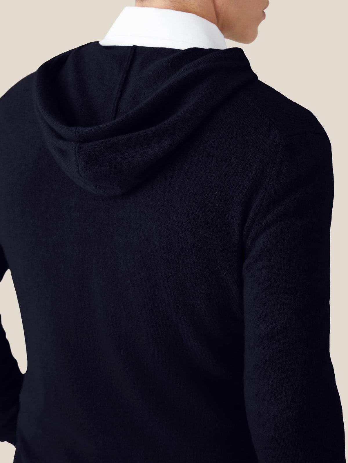 Back view of a man wearing a midnight blue cashmere hoodie over a white shirt, showcasing the hood detail.