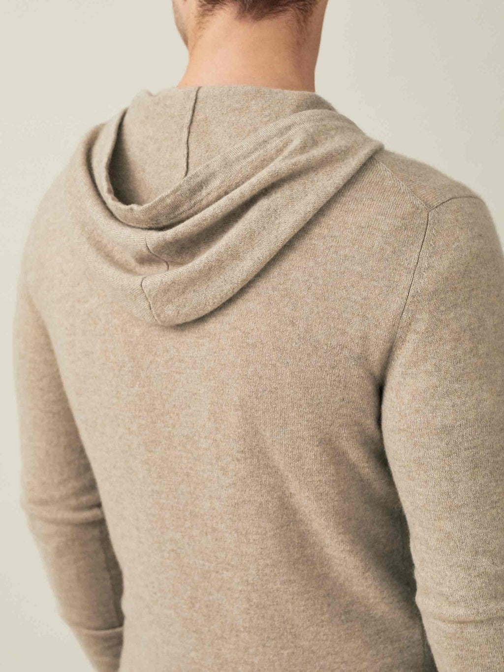 Close-up back view of a man wearing the Luca Faloni Cashmere Hoodie in Camel Beige, focusing on the hood and shoulder detail.