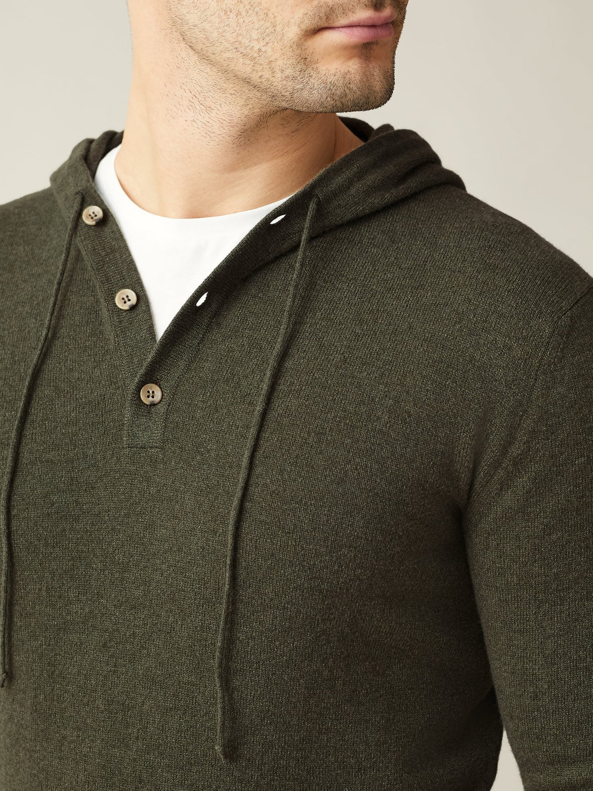 Close-up of the Luca Faloni Cashmere Hoodie in Hunting Green, showing the fine knit texture and horn button placket detail.