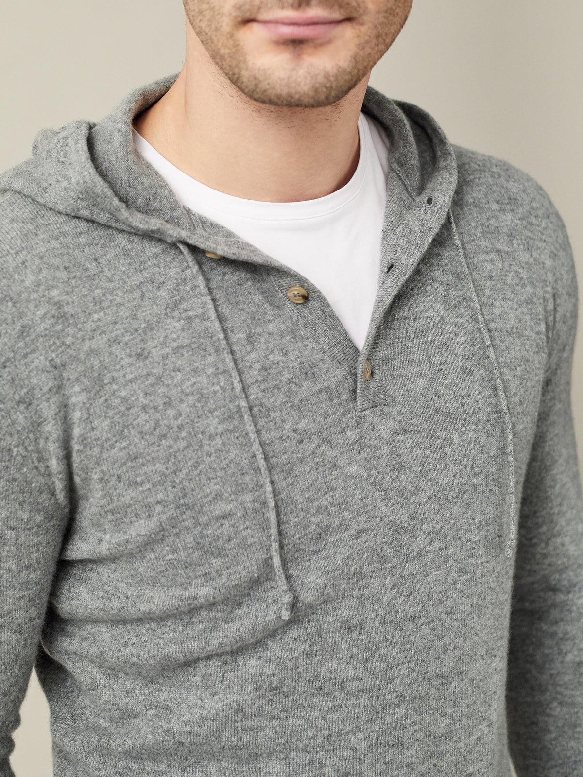 A close-up of the Luca Faloni Pure Cashmere Hoodie in Dolomiti Grey, showing the detail of the hood and three-button placket.