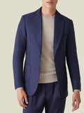 Front view of a man wearing the Navy Blue Wool Travel Blazer, styled with a beige knit and matching navy trousers.
