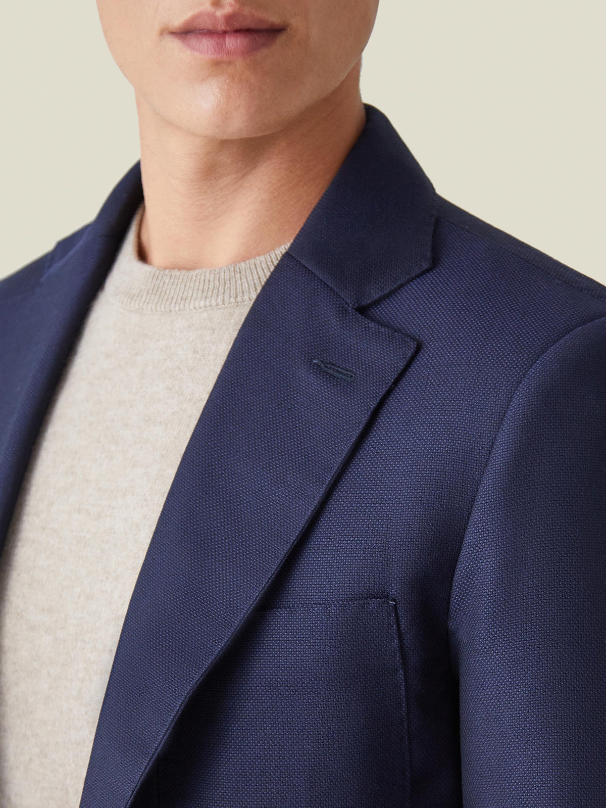 A close-up detail shot of the Navy Blue Wool Travel Blazer, highlighting the notch lapel and the fine wool texture.