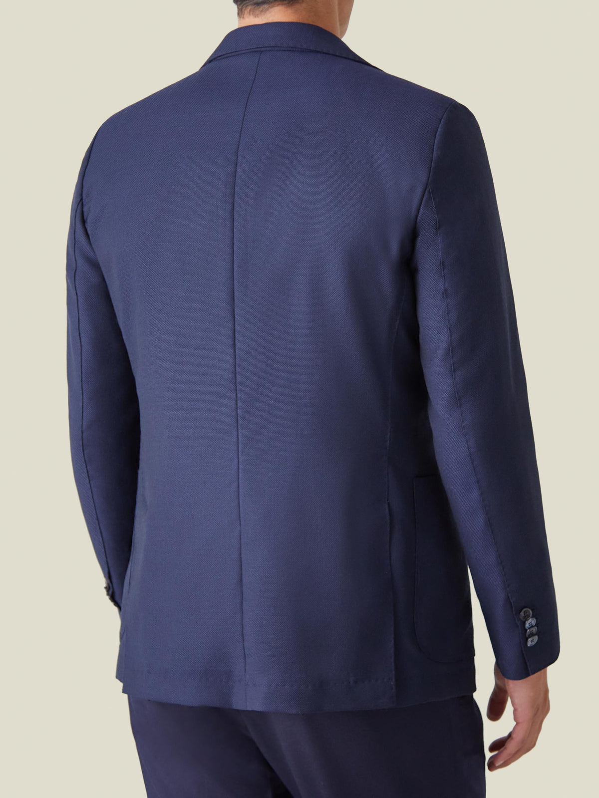 Back view of a man wearing the Navy Blue Wool Travel Blazer, highlighting the tailored fit and unstructured design.