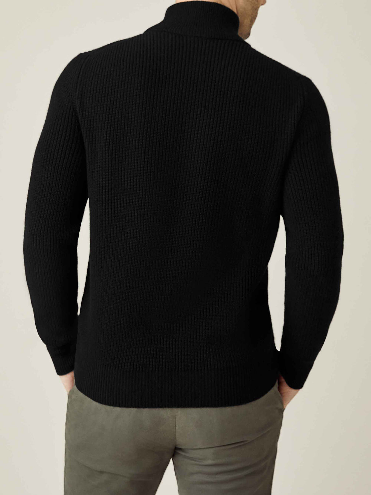 Rear view of a man wearing the Black Chunky Knit Cashmere Mock Neck, showing the ribbed texture and relaxed fit.