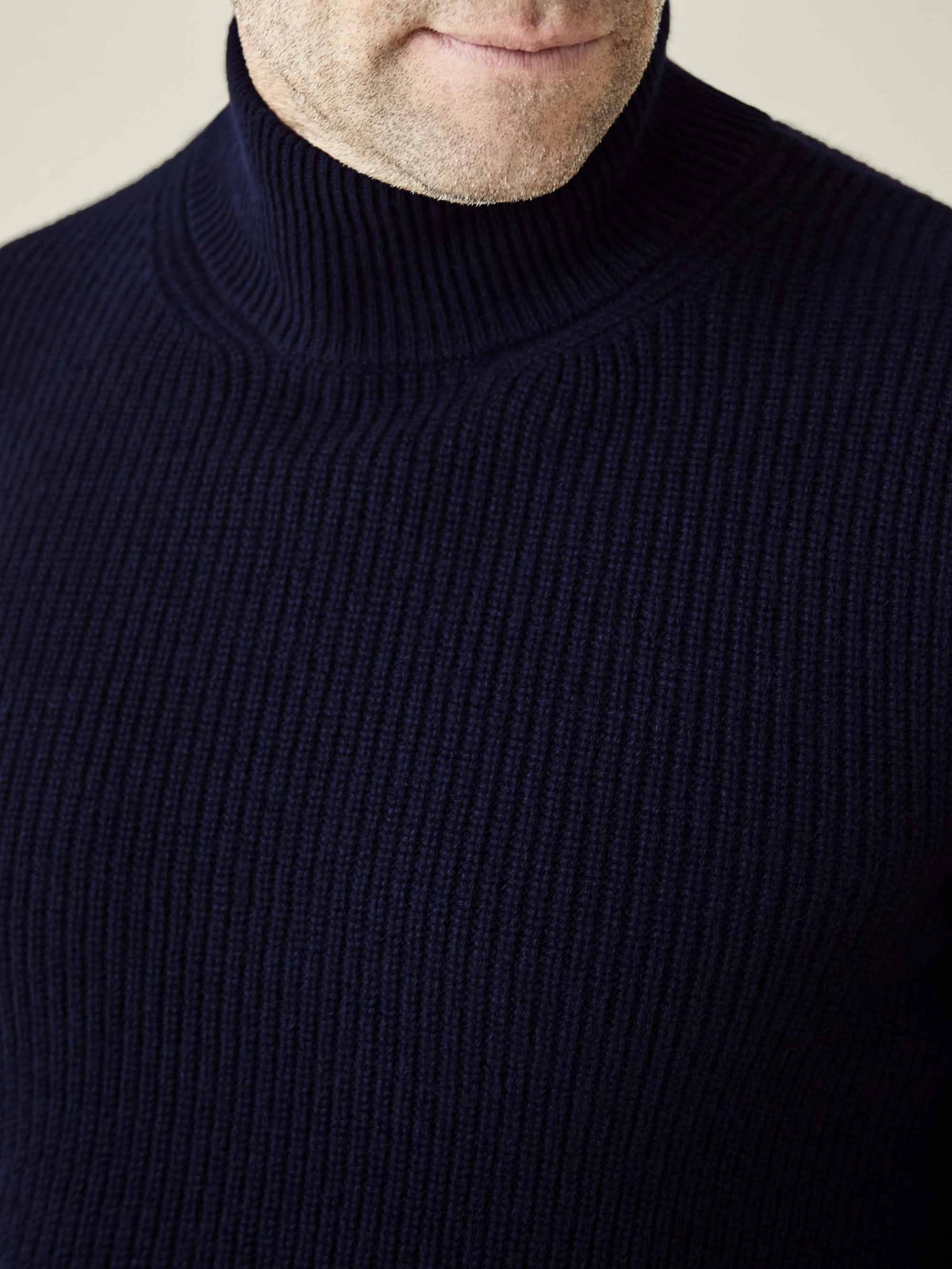A close-up view of the midnight blue Chunky Knit Mock Neck, showcasing the soft ribbed texture of its four-ply cashmere.
