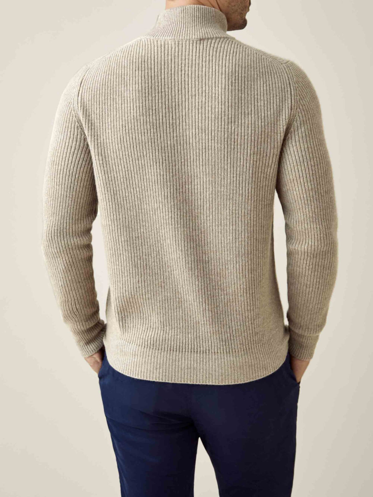 Back view of a model wearing the Chunky Knit Mock Neck in camel beige, showing the ribbed texture and relaxed fit.