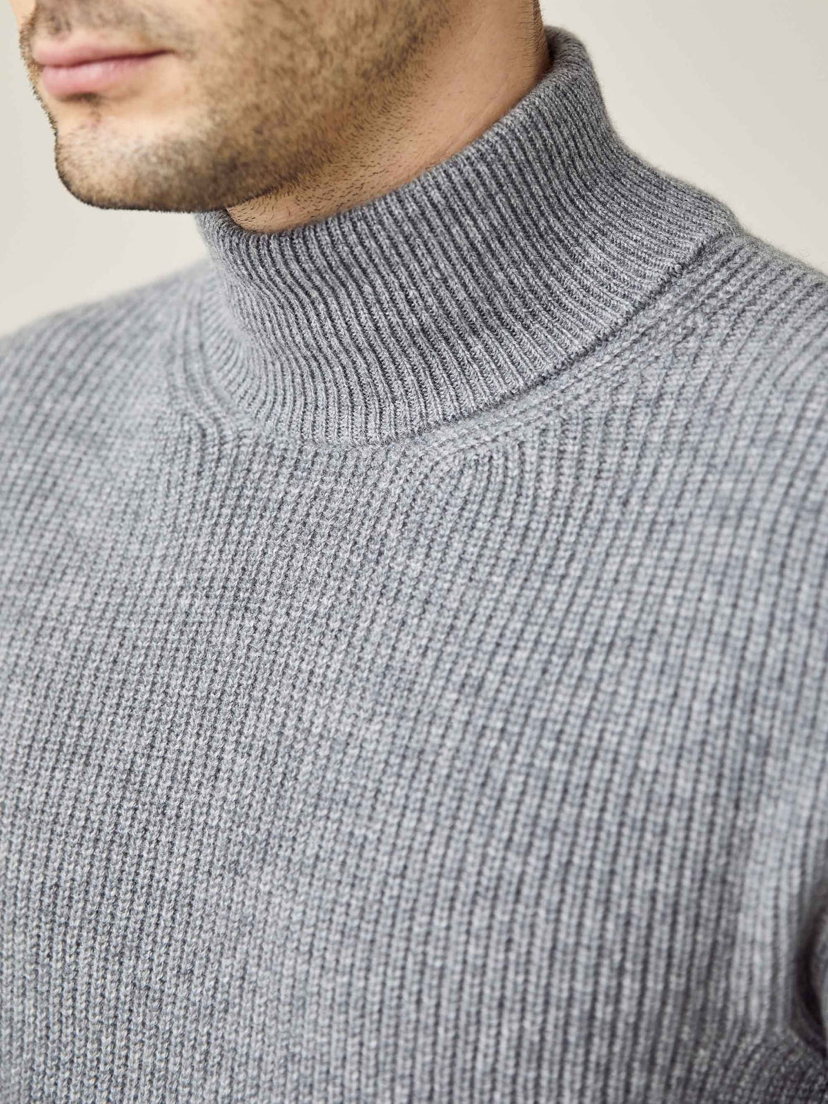A close-up of the ribbed funnel collar and knit texture of the Chunky Knit Mock Neck in Dolomiti Grey.