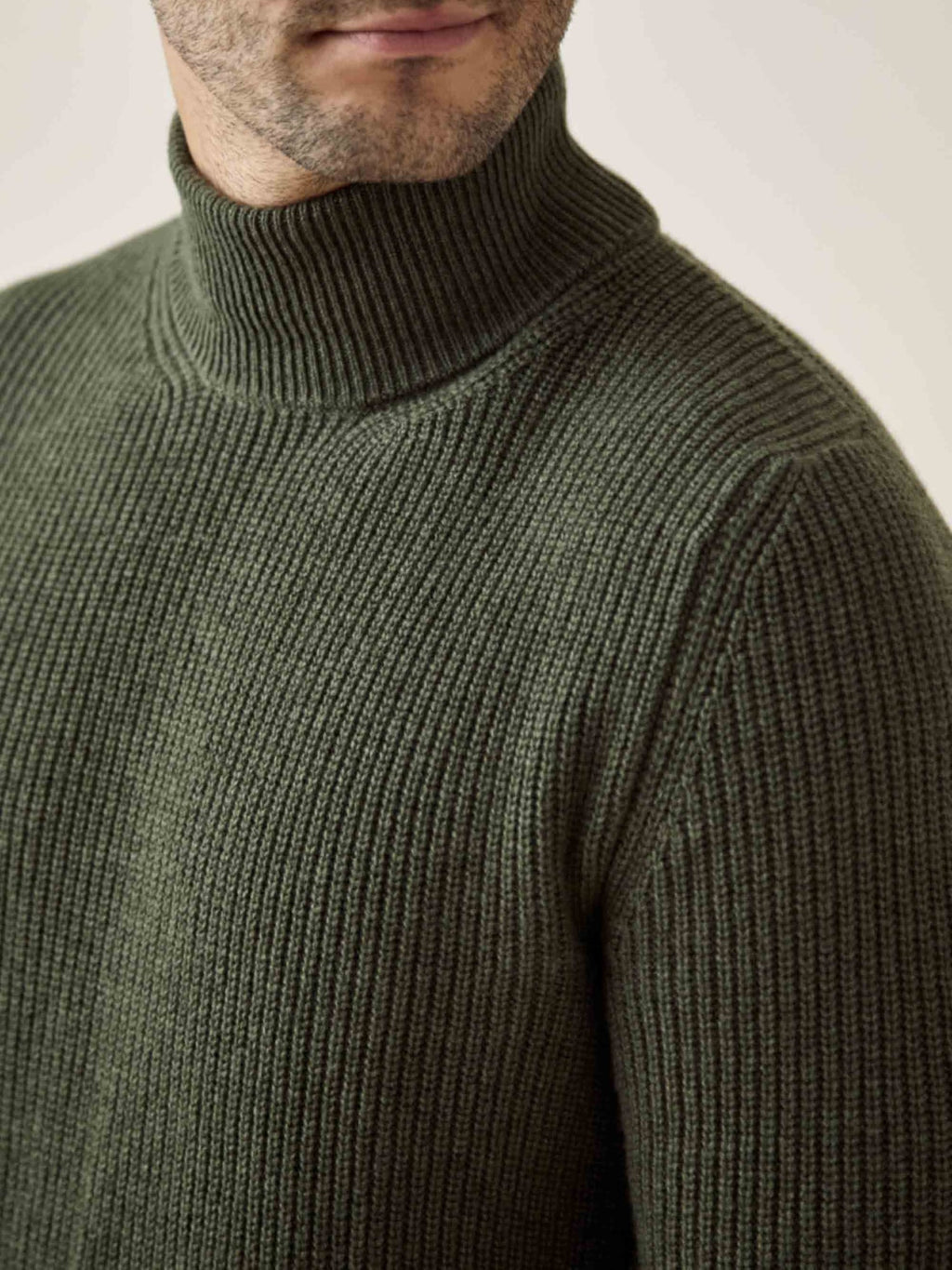 Close-up of a man wearing the Chunky Knit Mock Neck in Hunting Green, showing the ribbed four-ply cashmere texture.