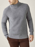 A model wears the Chunky Knit Mock Neck in Dolomiti Grey, showcasing the sweater's ribbed texture and relaxed silhouette.