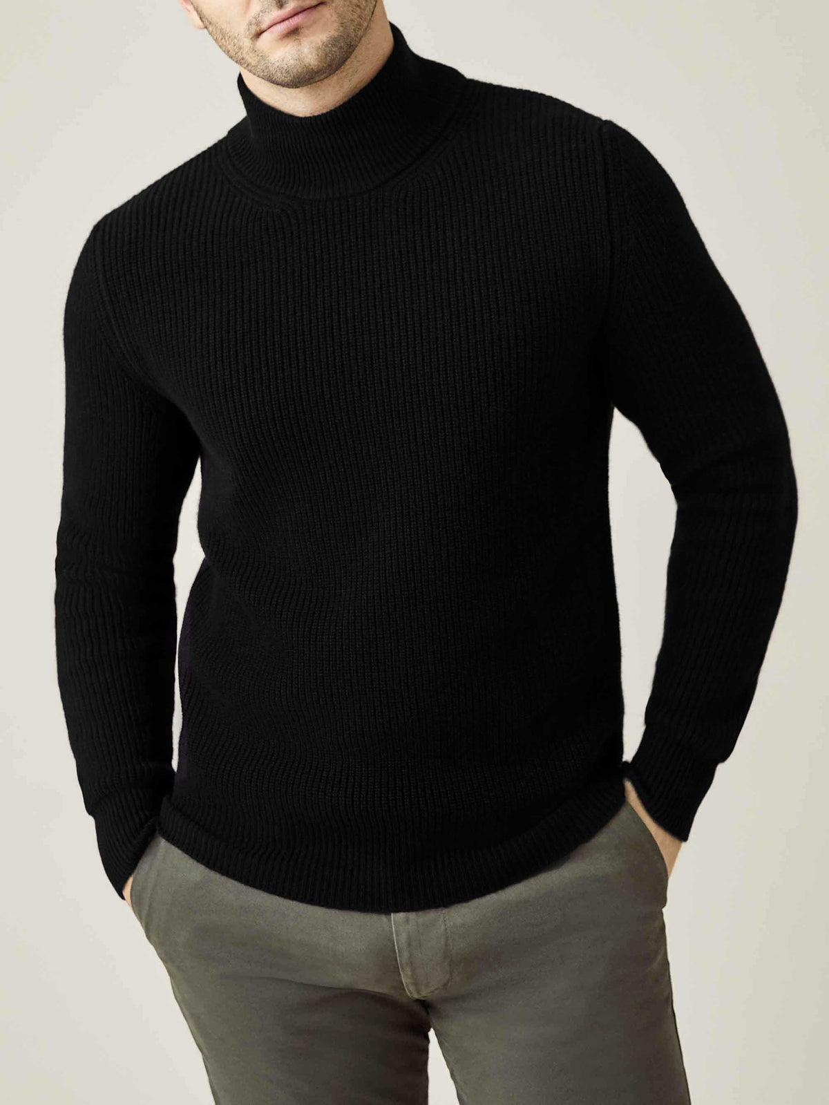 Front view of a model wearing the Luca Faloni Black Chunky Knit Cashmere Mock Neck with grey trousers.