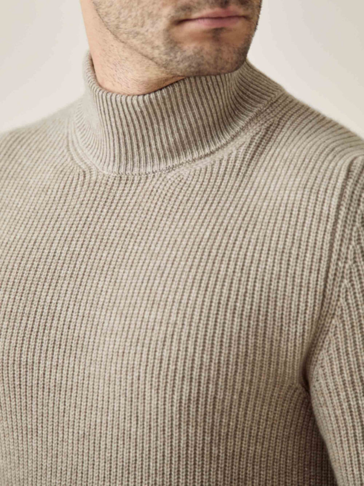 A close-up of a man wearing the Luca Faloni Chunky Knit Mock Neck in Camel Beige, highlighting the ribbed cashmere texture.