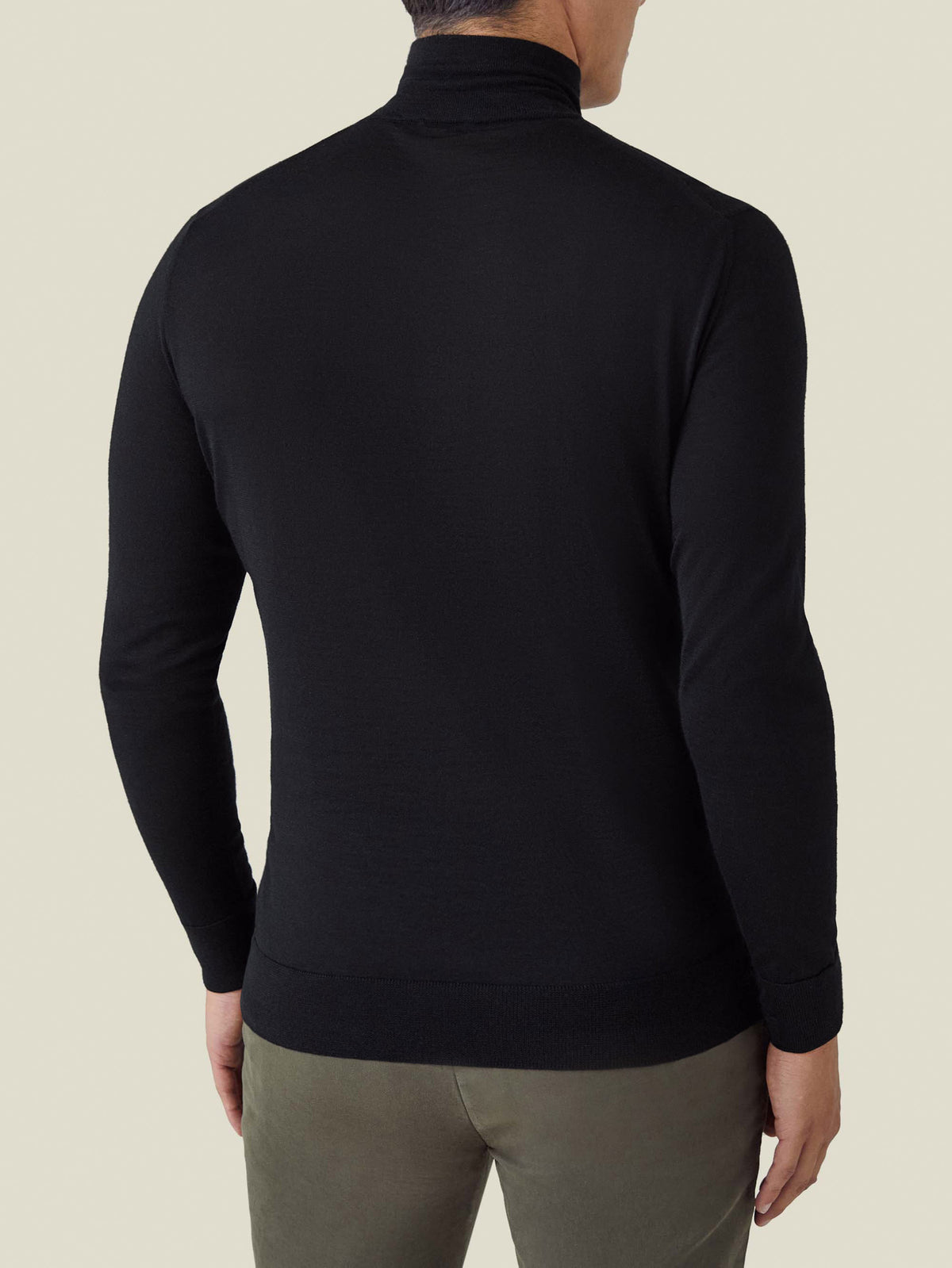 Back view of a model wearing the Luca Faloni Black Silk-Cashmere Mock Neck, showcasing its slim fit and ribbed hem.