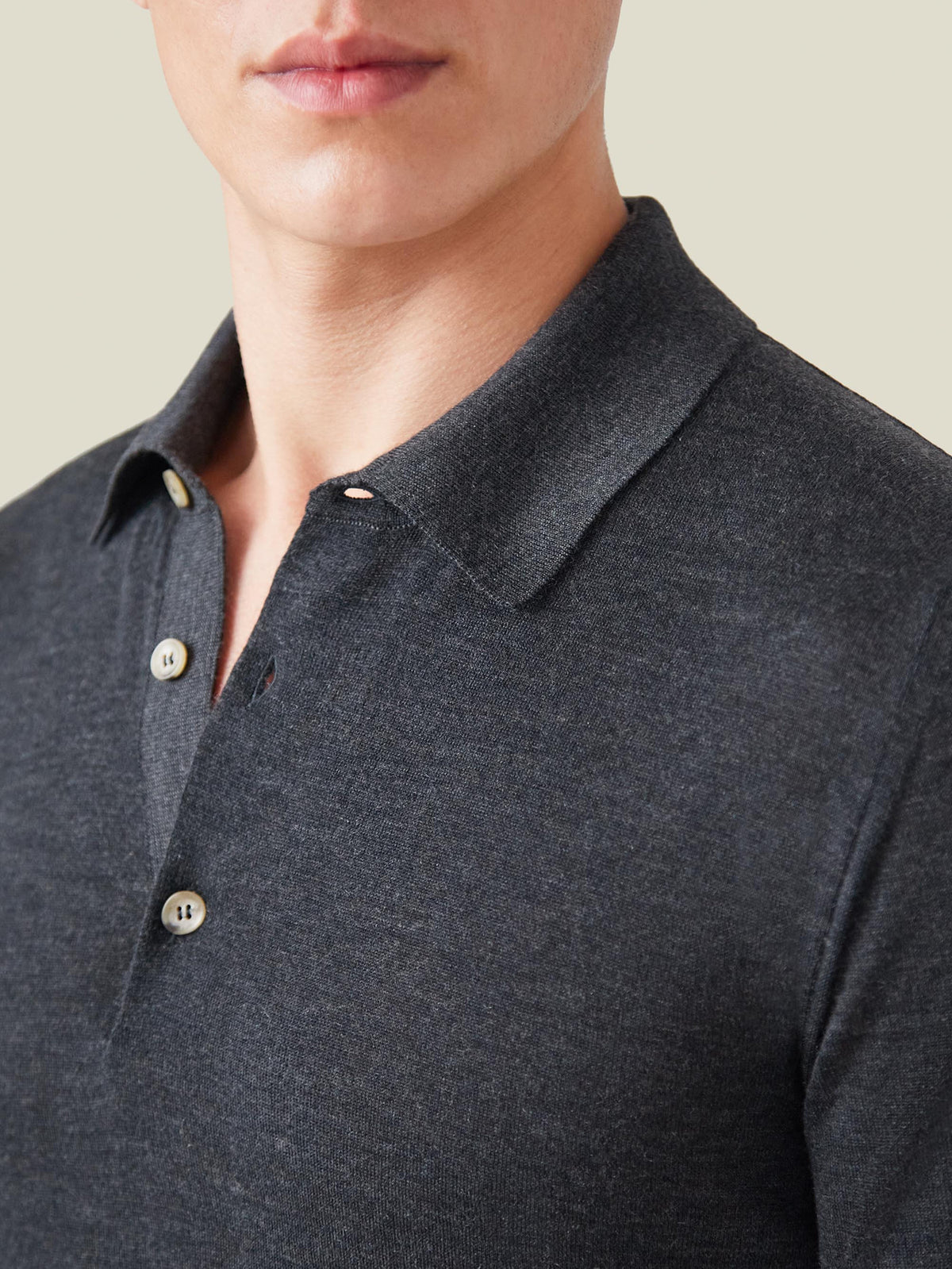 A close-up of a model wearing the charcoal grey Fine Silk Cashmere Polo, highlighting the collar and button details.