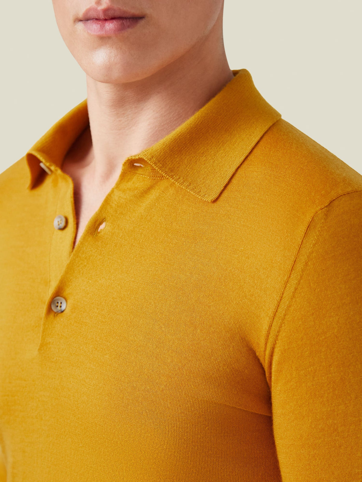 Close-up of the Fine Silk Cashmere Polo in mustard, detailing the spread collar, placket, and soft knitted texture.