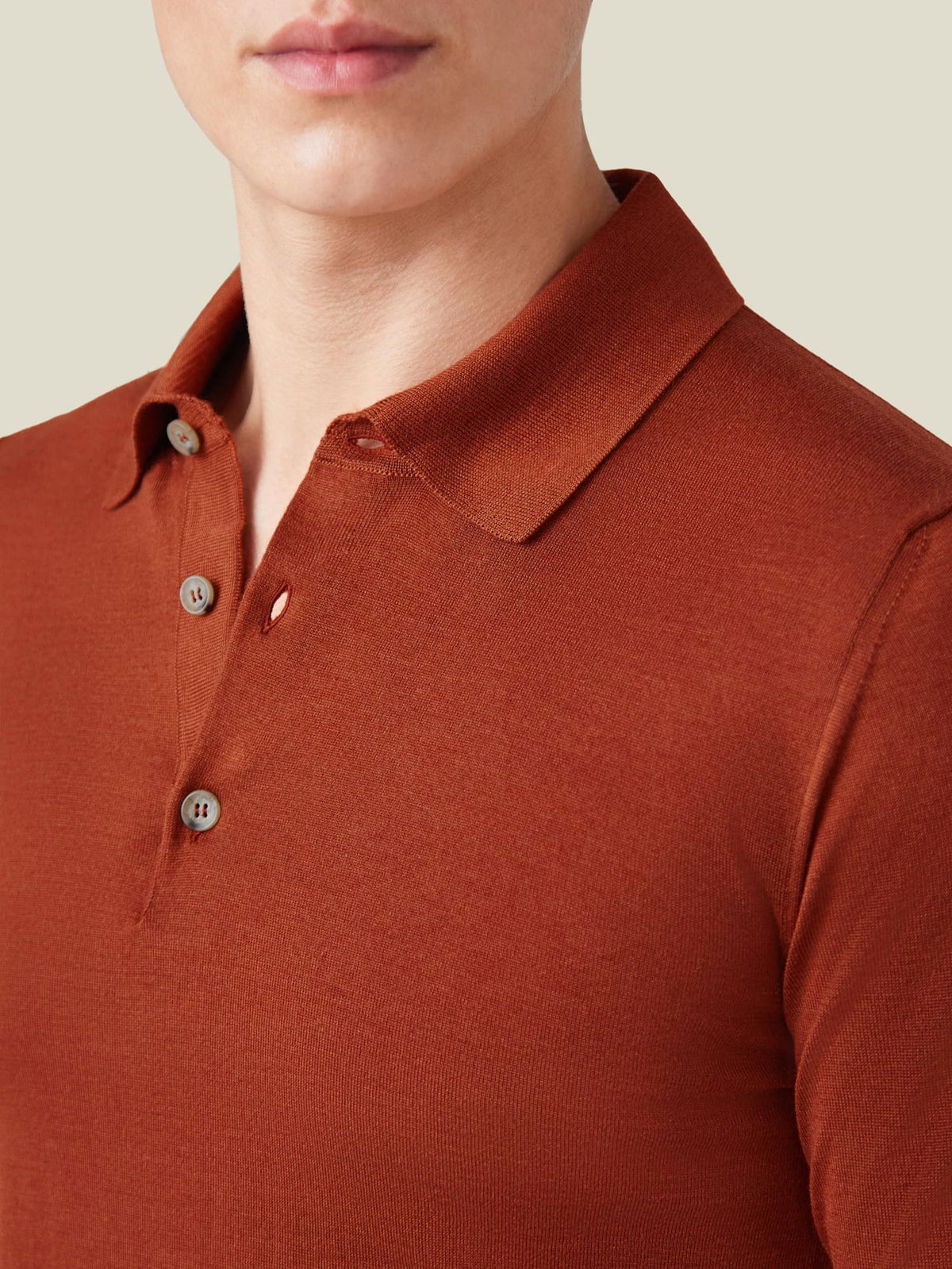 Close-up detail of a man wearing the Rust Fine Silk Cashmere Polo, focusing on the spread collar and button placket.