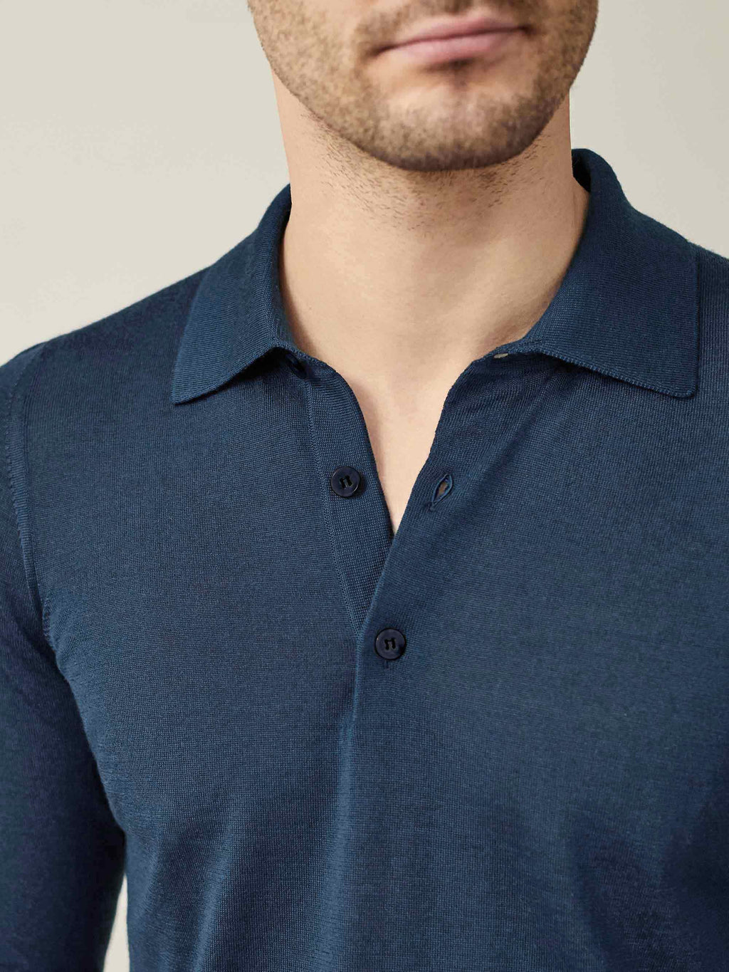 A close-up view of a model wearing the Atlantic Blue Fine Silk Cashmere Polo, highlighting the collar and button details.