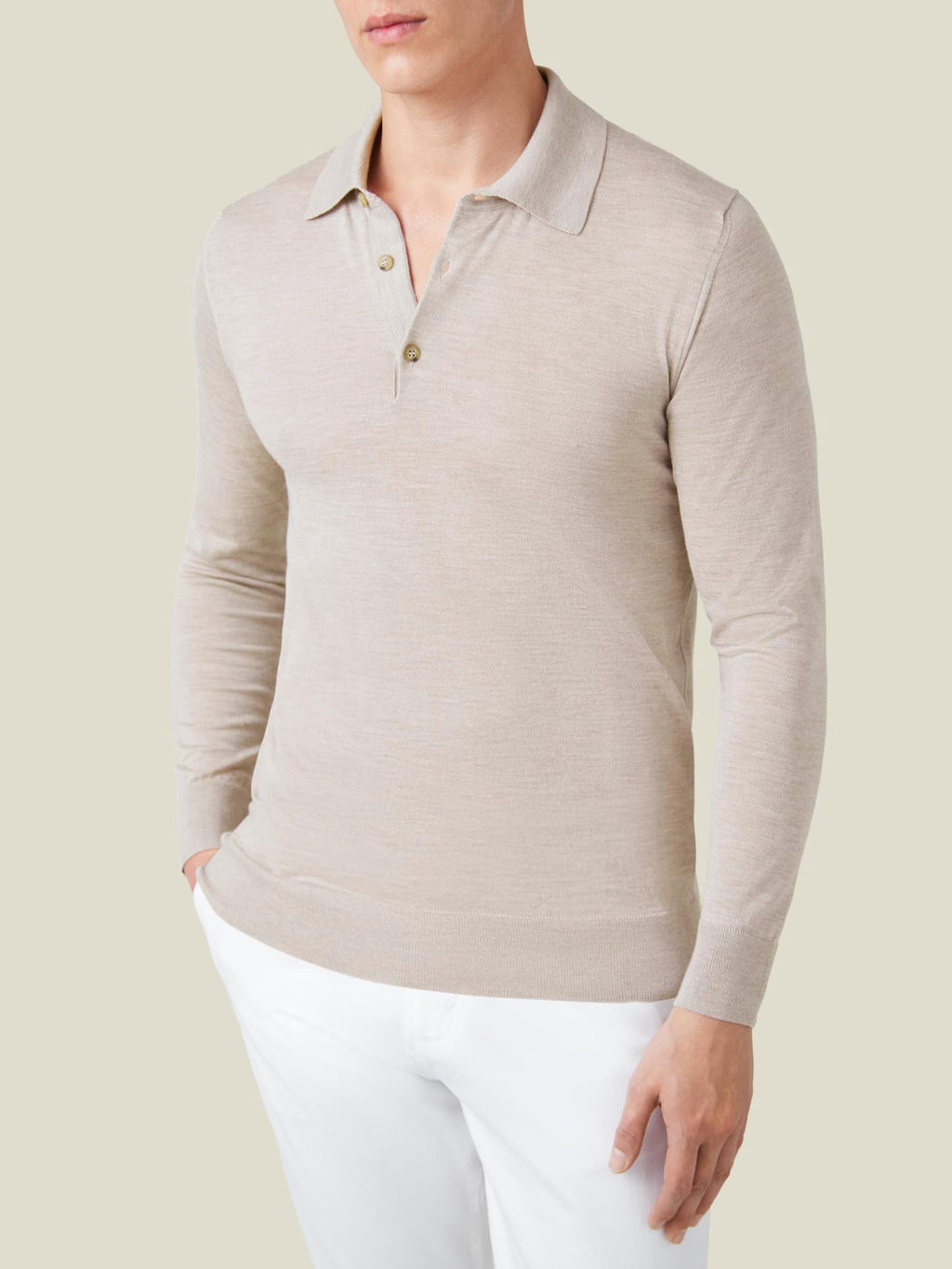 Front view of a model wearing the long-sleeved Fine Silk Cashmere Polo in Oatmeal, styled with white trousers.