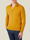 Front view of a model wearing the Fine Silk Cashmere Polo in Mustard with dark blue trousers.