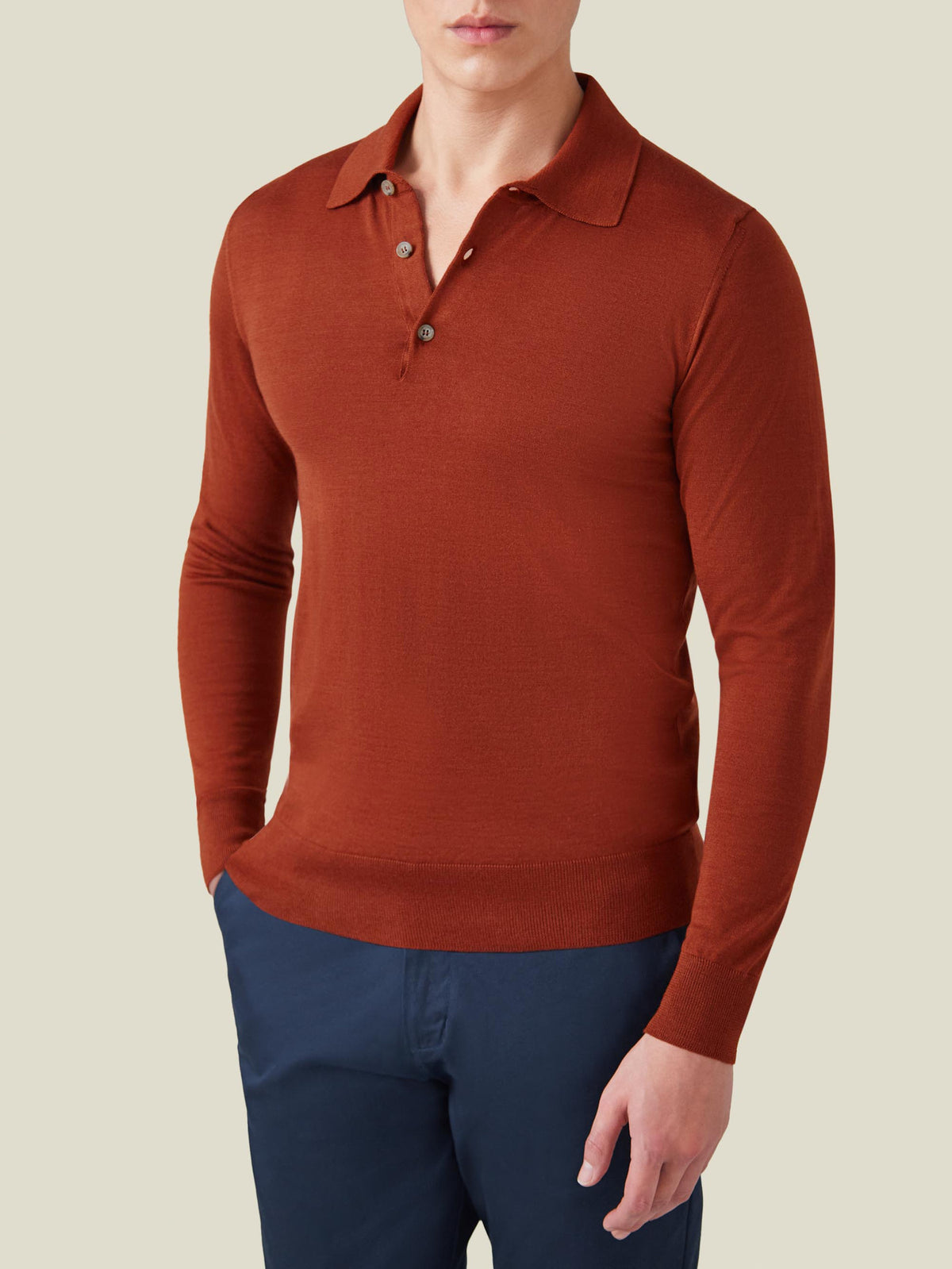Front view of a model wearing the Luca Faloni Fine Silk Cashmere Polo in Rust, paired with navy trousers.