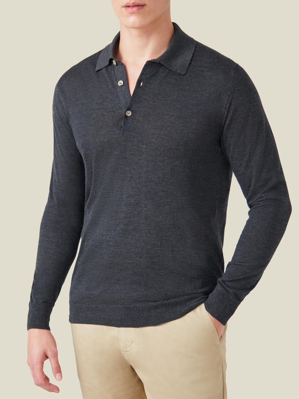 Front view of a model wearing the long-sleeved Fine Silk Cashmere Polo in Charcoal Grey with beige trousers.