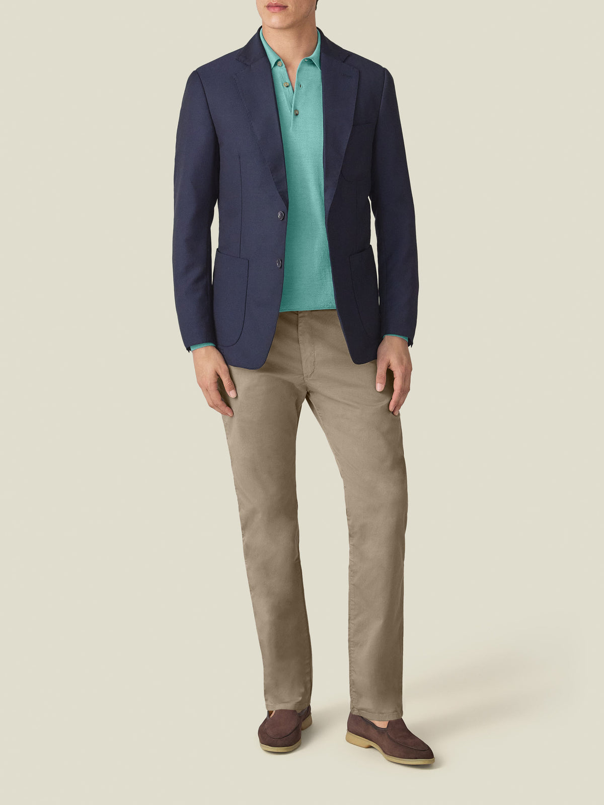 Model wears the Fine Silk Cashmere Polo in aquamarine, styled with a navy blazer and beige trousers.