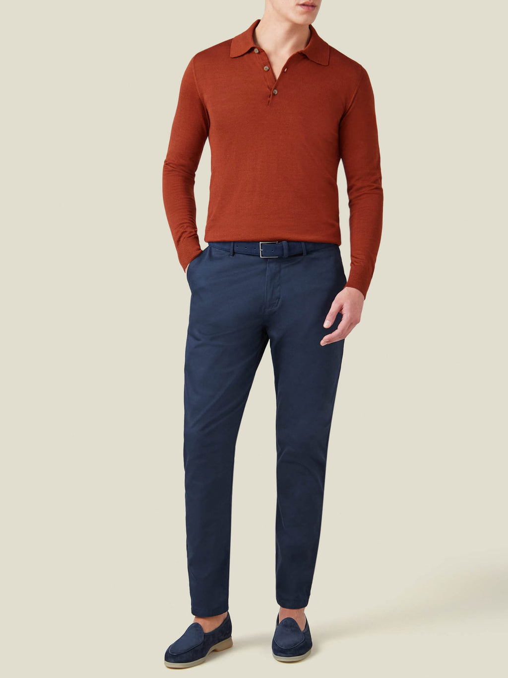Front view of a model wearing the Luca Faloni Fine Silk Cashmere Polo in Rust, paired with navy trousers and loafers.